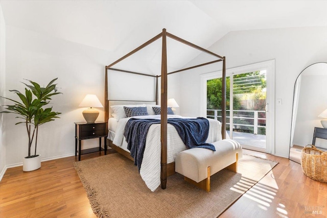bedroom featuring lofted ceiling, access to outside, and light wood-style floors