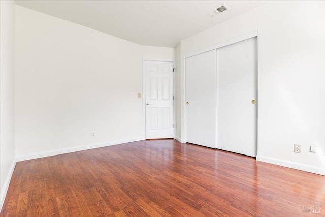 unfurnished bedroom with visible vents, baseboards, and wood finished floors