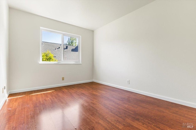 empty room featuring baseboards and wood finished floors