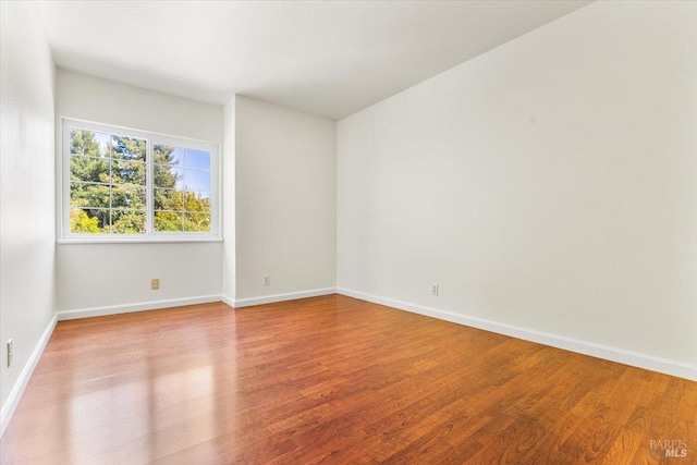 empty room with wood finished floors and baseboards