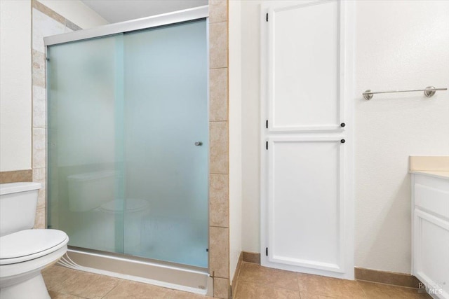 full bath featuring a stall shower, tile patterned floors, vanity, and toilet