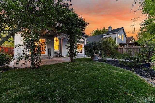 back of property featuring a yard, a patio, and fence
