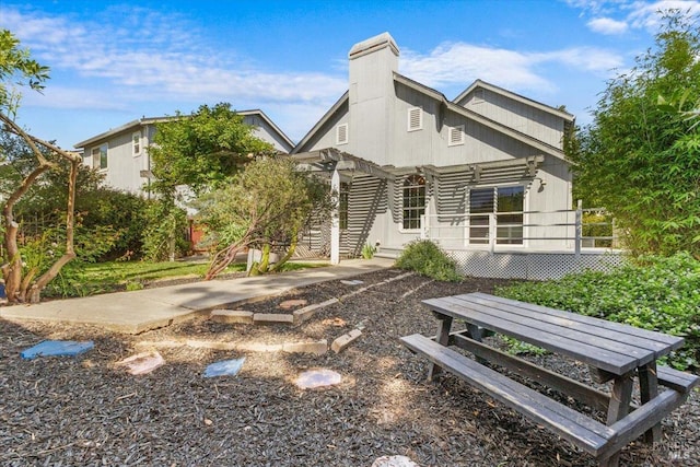 back of property featuring a chimney and a porch