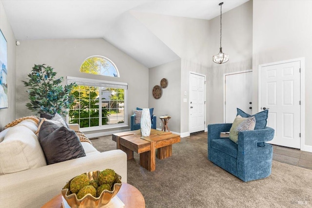 carpeted living room with baseboards, an inviting chandelier, and high vaulted ceiling
