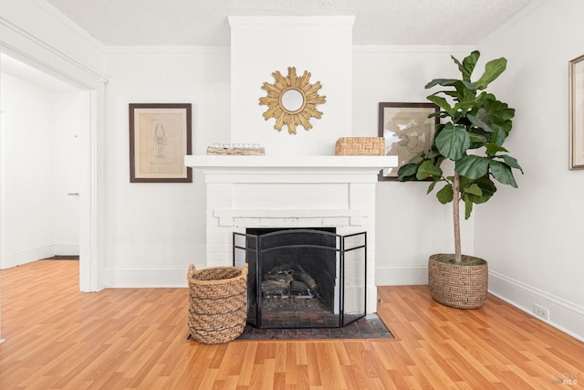 details featuring baseboards, crown molding, a brick fireplace, and wood finished floors