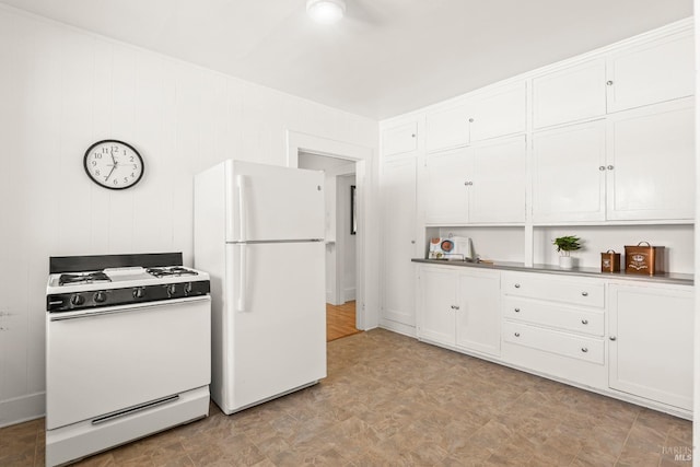 kitchen featuring light floors, white cabinetry, and white appliances