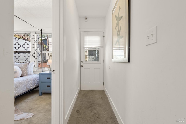hall featuring carpet floors and baseboards