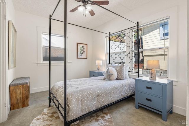 carpeted bedroom featuring baseboards, ceiling fan, and multiple windows