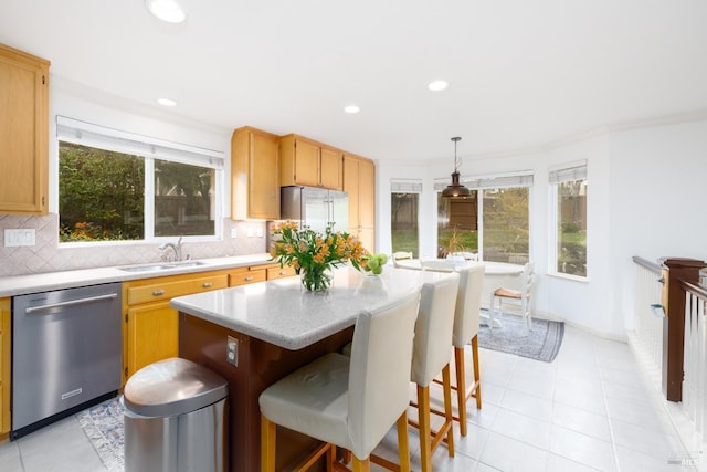 kitchen with light countertops, a sink, backsplash, and appliances with stainless steel finishes
