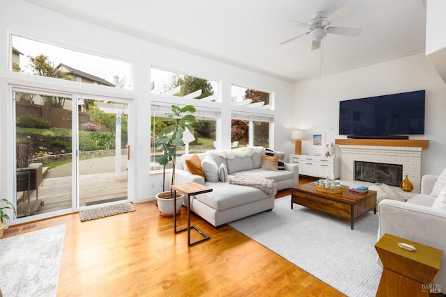 living area with wood finished floors, a fireplace, and ceiling fan