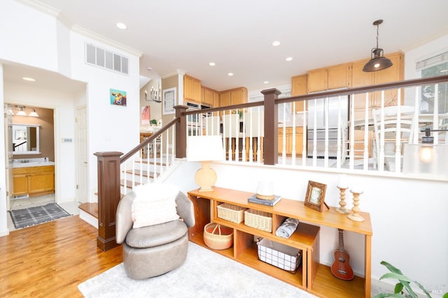 interior space featuring ornamental molding, wood finished floors, visible vents, and recessed lighting