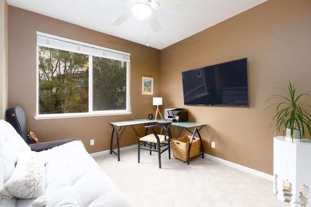 carpeted home office featuring baseboards and ceiling fan