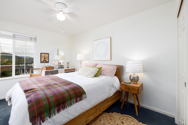 carpeted bedroom with a closet, baseboards, and ceiling fan