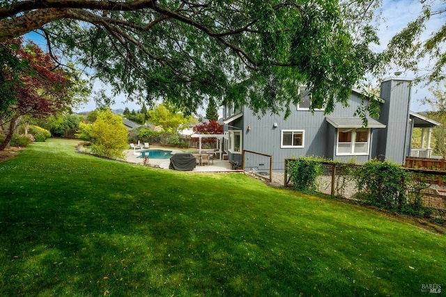 view of yard featuring fence, an outdoor pool, and a patio area
