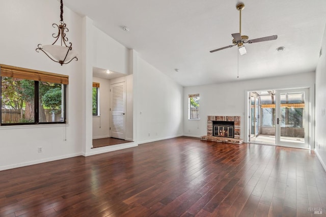 unfurnished living room featuring a ceiling fan, a fireplace, wood finished floors, high vaulted ceiling, and baseboards