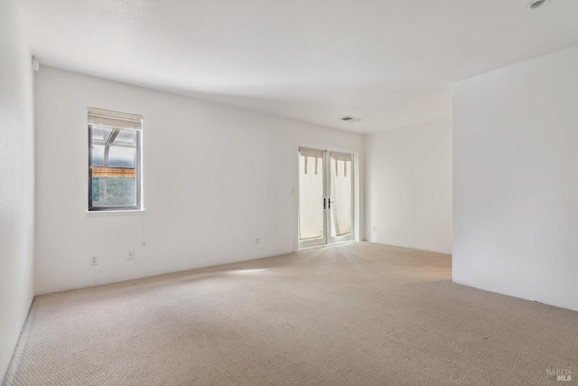 carpeted spare room featuring visible vents