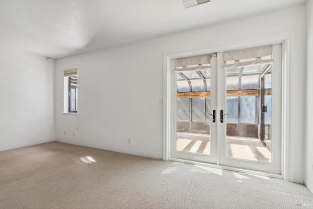 unfurnished room with french doors, carpet flooring, and visible vents