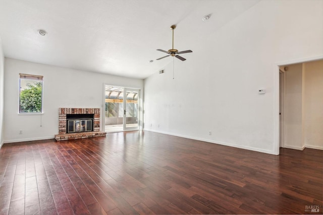 unfurnished living room with baseboards, dark wood finished floors, and a wealth of natural light