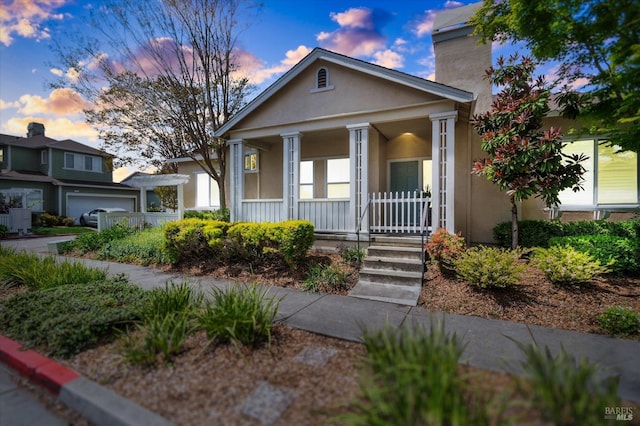 neoclassical home with covered porch and stucco siding