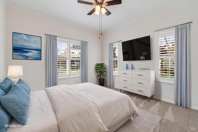 bedroom with ceiling fan, baseboards, and light colored carpet
