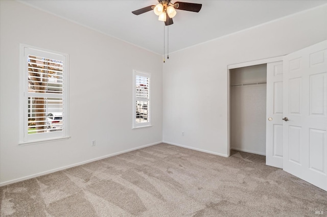 unfurnished bedroom featuring carpet, a closet, baseboards, and ceiling fan