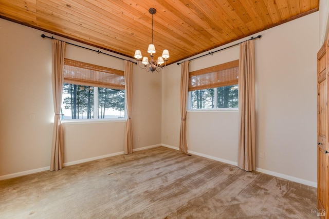 carpeted spare room featuring baseboards, plenty of natural light, wooden ceiling, and an inviting chandelier