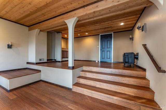 stairs featuring wooden ceiling, a wood stove, hardwood / wood-style floors, and recessed lighting