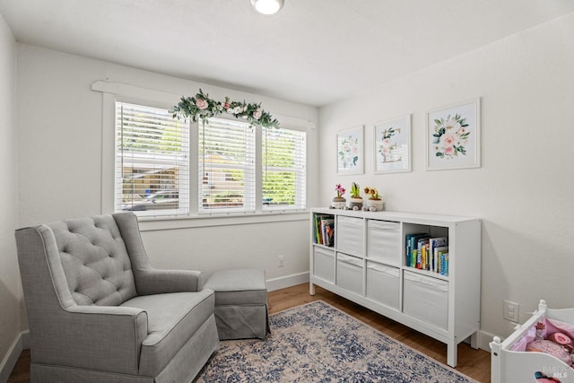 sitting room with baseboards, wood finished floors, and a wealth of natural light