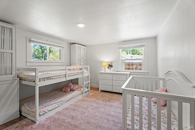 bedroom with light wood-type flooring and a textured ceiling
