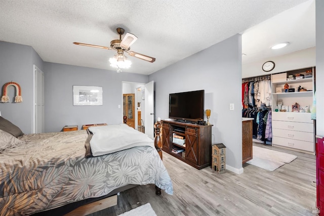 1119 Clelia Ct, Petaluma, CA 94954 - bedroom with a closet, a walk in closet, a textured ceiling, a ceiling fan, and light wood-style flooring