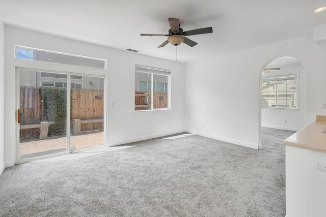 unfurnished room with visible vents, ceiling fan, a healthy amount of sunlight, and carpet flooring