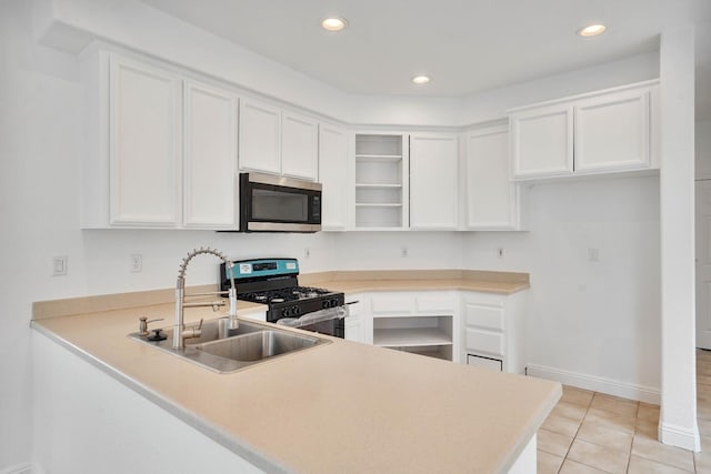 kitchen featuring white cabinetry, open shelves, a sink, stainless steel appliances, and a peninsula