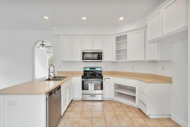 kitchen with a peninsula, a sink, open shelves, and stainless steel appliances