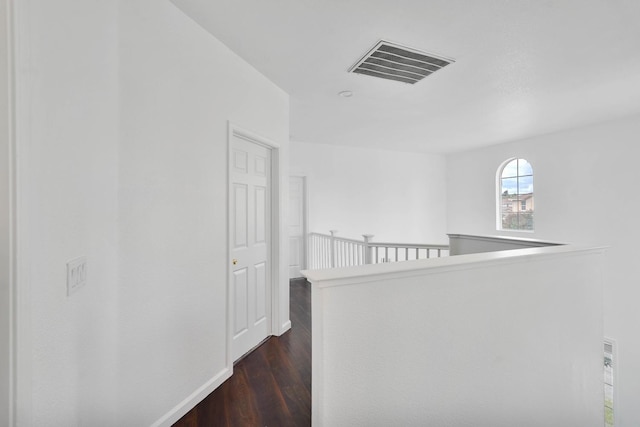 hall featuring an upstairs landing, visible vents, dark wood-style flooring, and baseboards