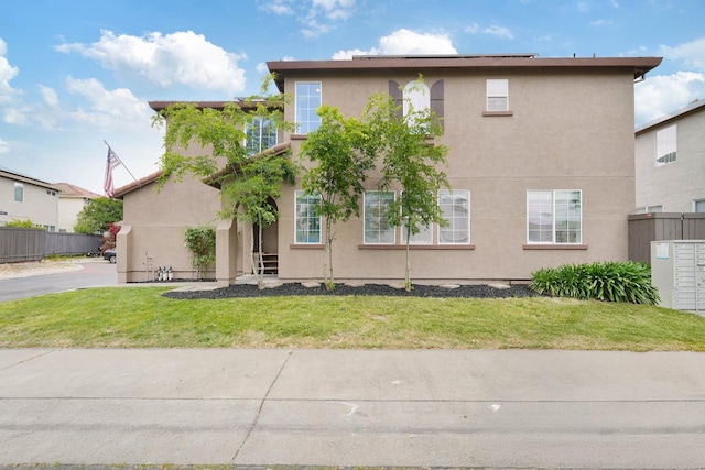 view of front of house featuring a front lawn and stucco siding
