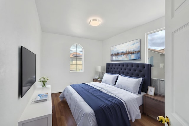 bedroom with wood finished floors and multiple windows