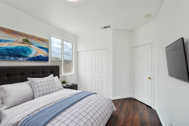 bedroom featuring a closet, visible vents, wood finished floors, and baseboards