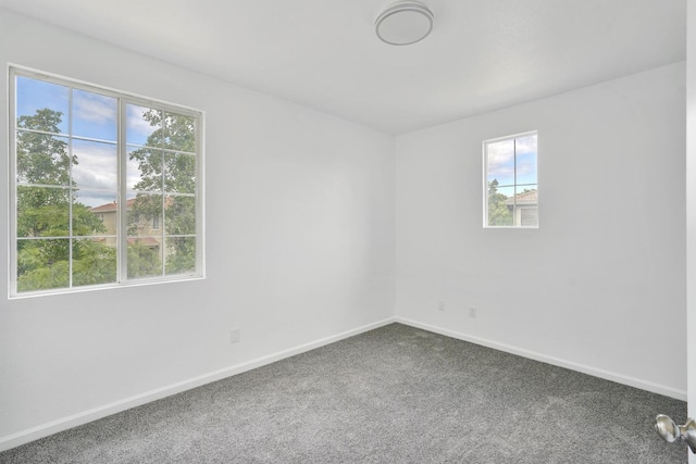 carpeted spare room featuring baseboards