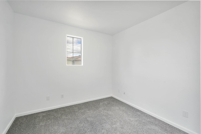 unfurnished room with baseboards and carpet floors