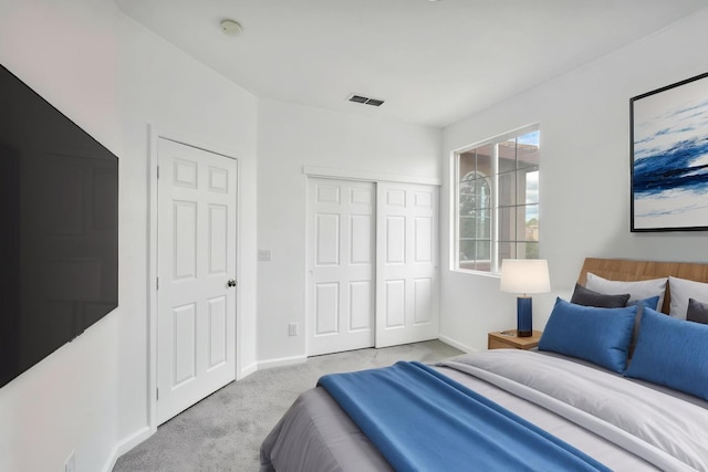 bedroom with carpet, visible vents, a closet, and baseboards
