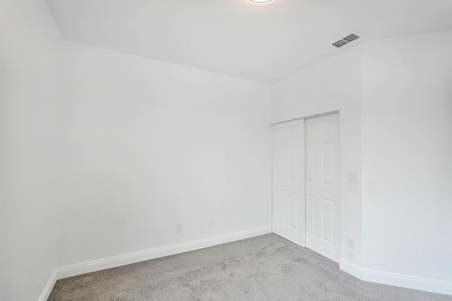 spare room with baseboards, visible vents, and carpet