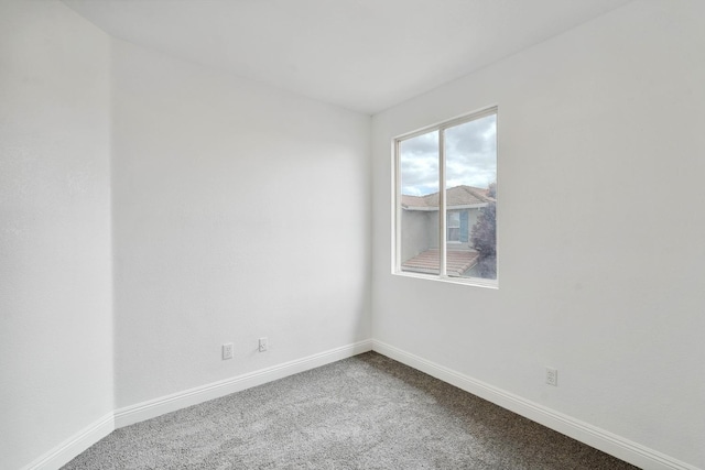 empty room featuring carpet flooring and baseboards