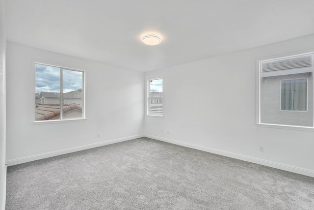 carpeted spare room featuring baseboards