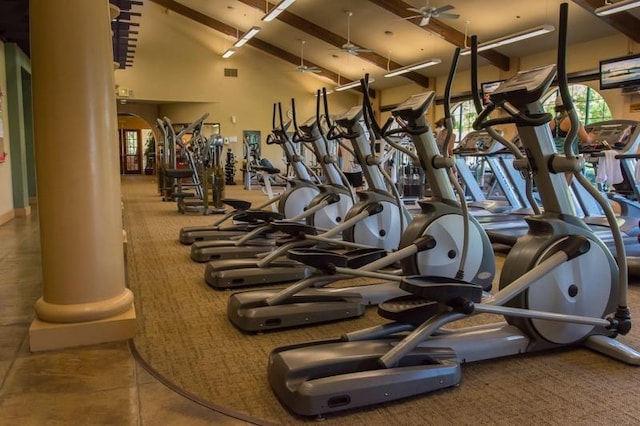 exercise room with carpet flooring, a high ceiling, ceiling fan, and ornate columns