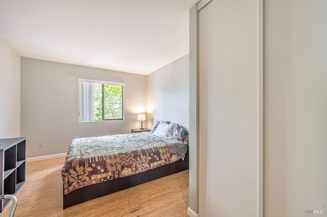 bedroom featuring wood finished floors and baseboards