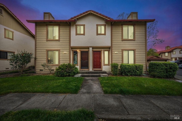 townhome / multi-family property featuring a chimney and a front yard