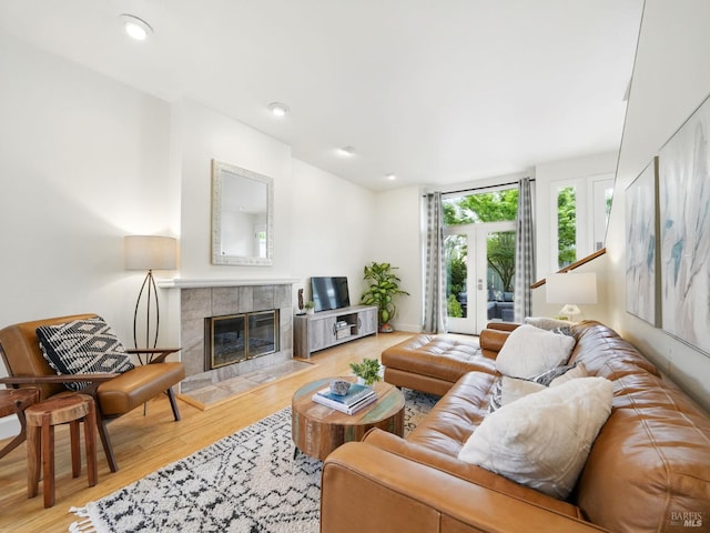 living area with a fireplace, wood finished floors, and baseboards