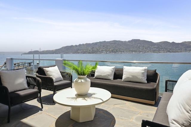 view of patio / terrace with outdoor lounge area, a balcony, and a water and mountain view