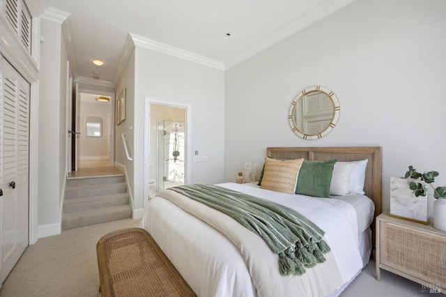 carpeted bedroom with visible vents, crown molding, baseboards, and connected bathroom