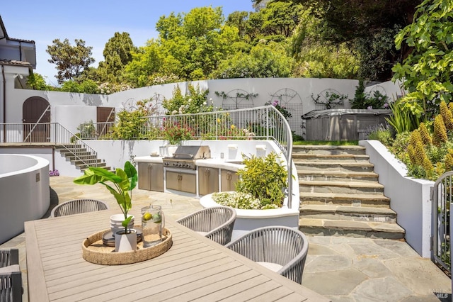 view of patio / terrace with stairway, outdoor dining area, a fenced backyard, a hot tub, and area for grilling